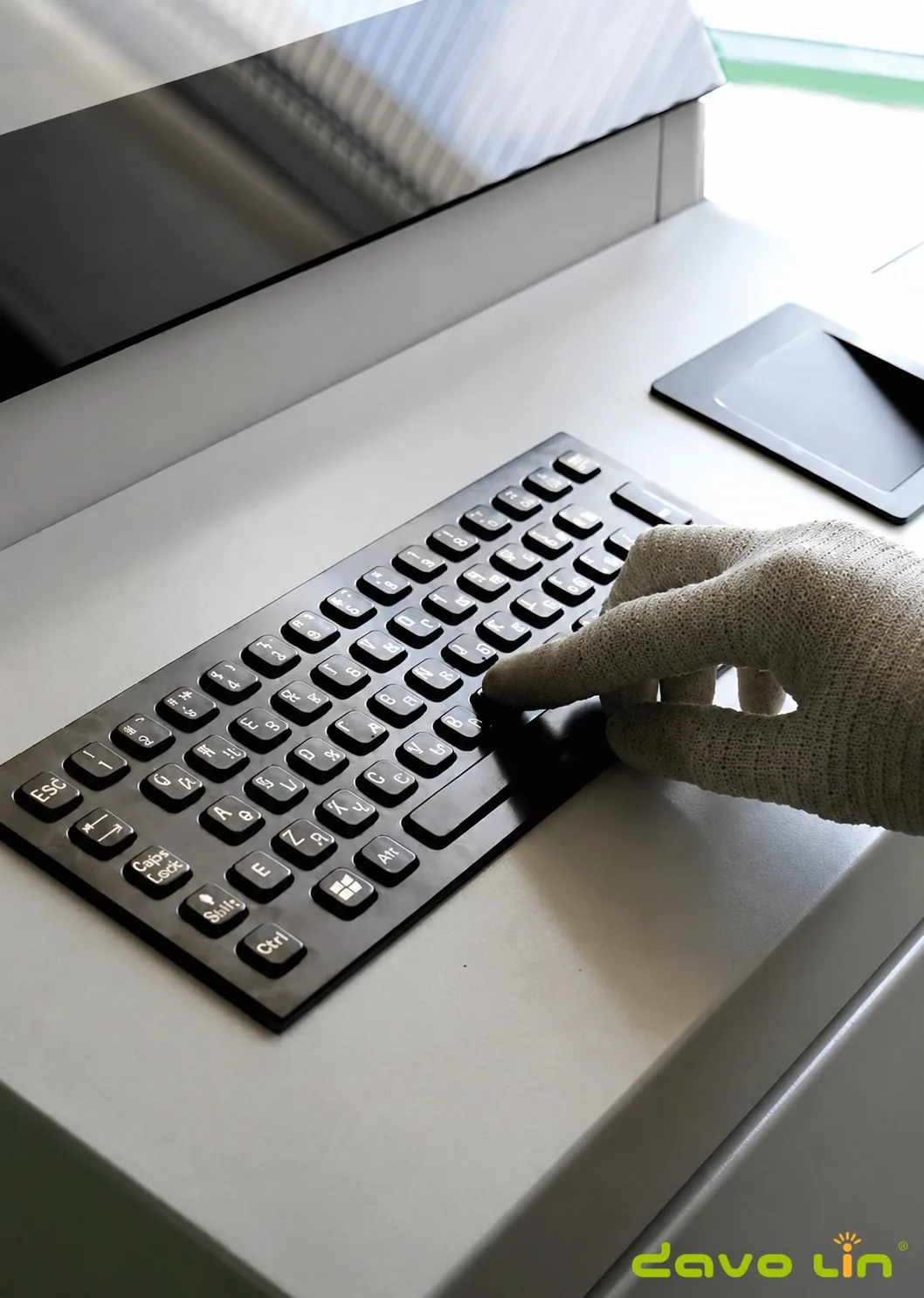 Industrial operator using the metal keyboard while wearing work gloves
